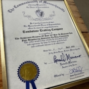 State Rep Donnie Berthiaume presents a certificate recognizing Tombstone Trading Company's 20th year in business.